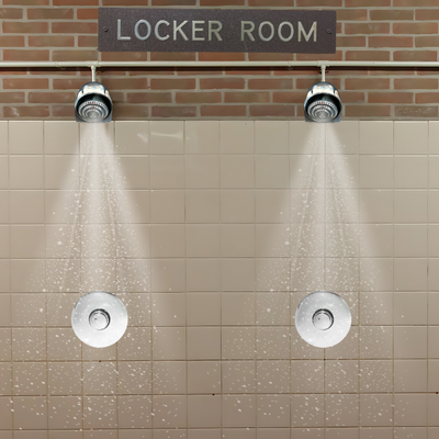 indoor push button shower valve with anti-ligature shower head in a high school gym locker room